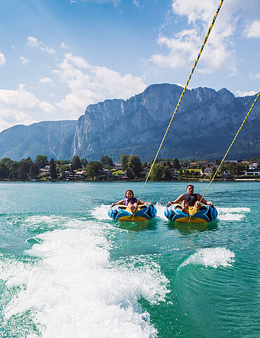 Seen & Wassersport Paar bei Reifen-Fahrt am Mondsee