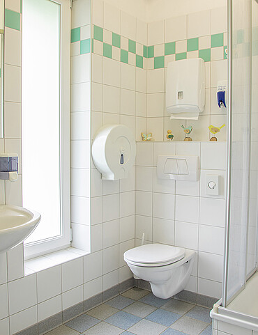 Bad mit Waschbecken, Dusche und Toilette in der Sanitäranlage vom Camp Mondseeland